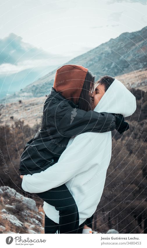 Happy couple kissing with a mountain in the background Infatuation Related Harmonious Trust Relationship Together Lovers Snapshot Couple Near Freedom Peace Blue