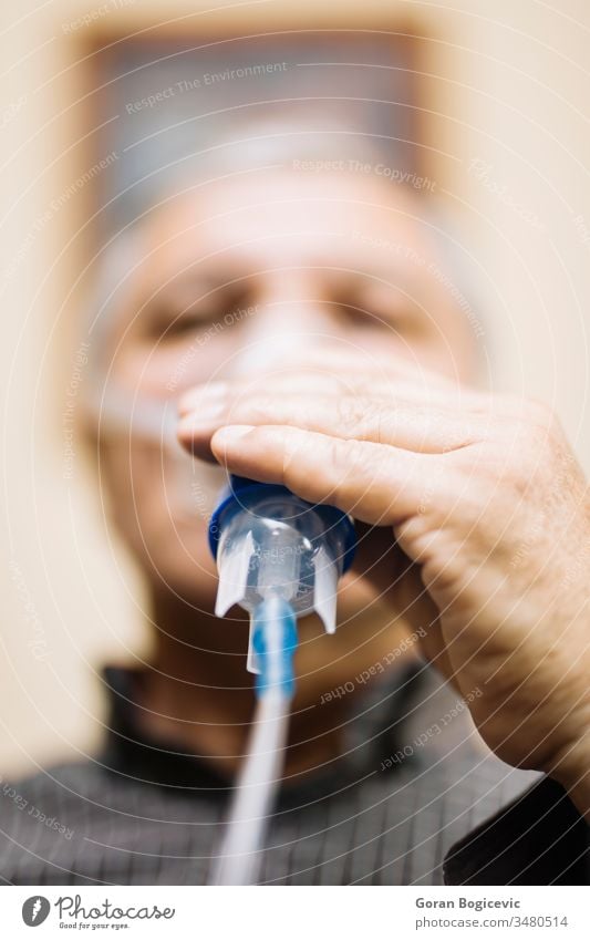 Senior man using medical equipment for inhalation with respiratory mask, nebulizer aerosol air allergy asthma asthmatic breath breathing bronchial bronchitis