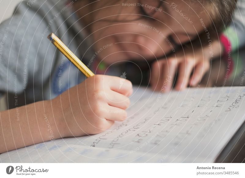 Little seven years old girl doing homework education student writing 7s sitting people person kid pencil child childhood children candid one concentration