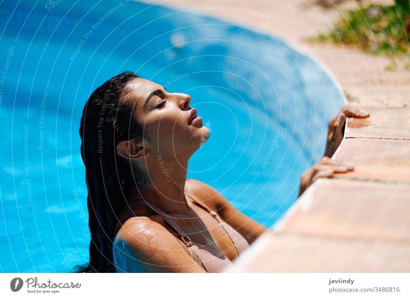 Beautiful Arab woman relaxing in swimming pool. summer beautiful bikini young water girl female sunbathing beauty body attractive sunny resort tanned happy