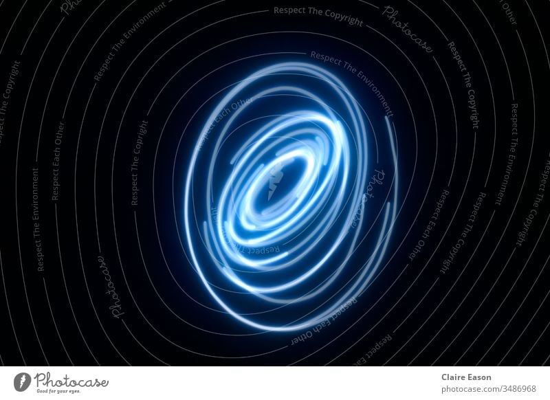 A pale blue spiral light trail with a black background Spiral long exposure Experimental glowing curves light movement