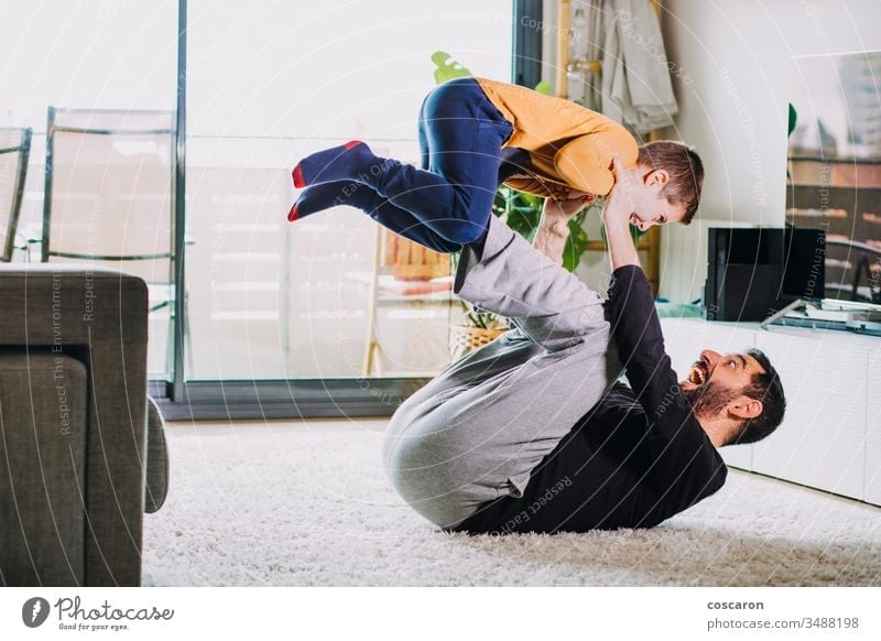 Father and son playing at home adorable air baby bonding boy candid laughter child childcare fun childhood childhood care coronavirus covid-19 dad dad laugh