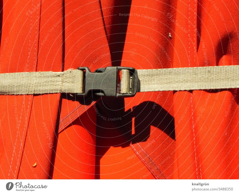 brown lashing strap with black buckle holds a red parasol together Sunshade Belt Protection stick together Red Shadow Weather protection Cotton fabric Cloth