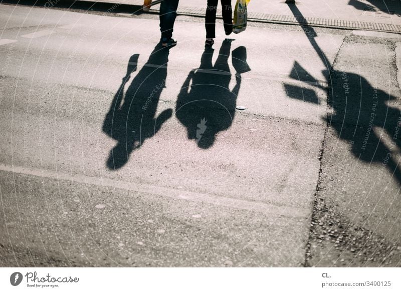 shadows of two people in the street Pedestrian Going Couple Movement Shadow Street Shadow play To go for a walk take a walk Shopping Shopping Bags