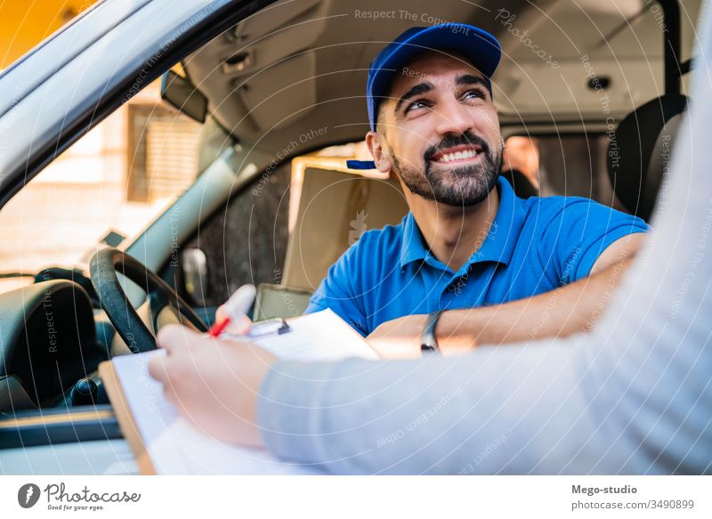 Delivery man in van while customer sign in clipboard. male service package delivery shipping industry work send office closeup logistic consumer carrying