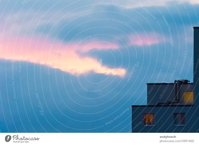 Alone at the window when evening the sun went down abstract alone apartment architecture blue building building exterior city cloud clouds copy space dark