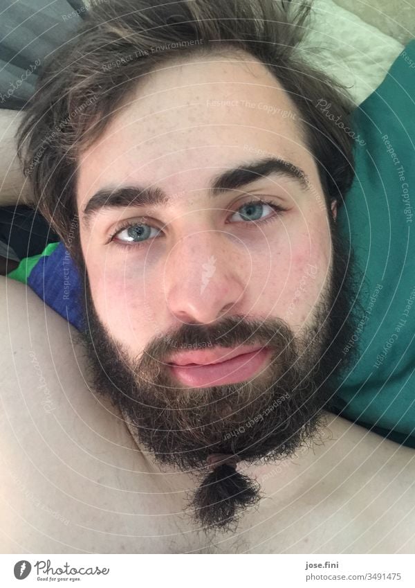 His hairdresser wasn't open for a long time, so he tied a braid in his beard Young man good-looking Portrait photograph Morning Bed Man Masculine Beard
