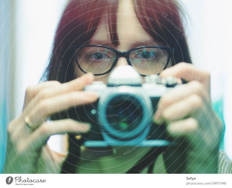 Young girl with glasses making selfie on camera digital portrait cinema mirror woman auto mirrorless lift dark wearing young red hair caucasian italian russian