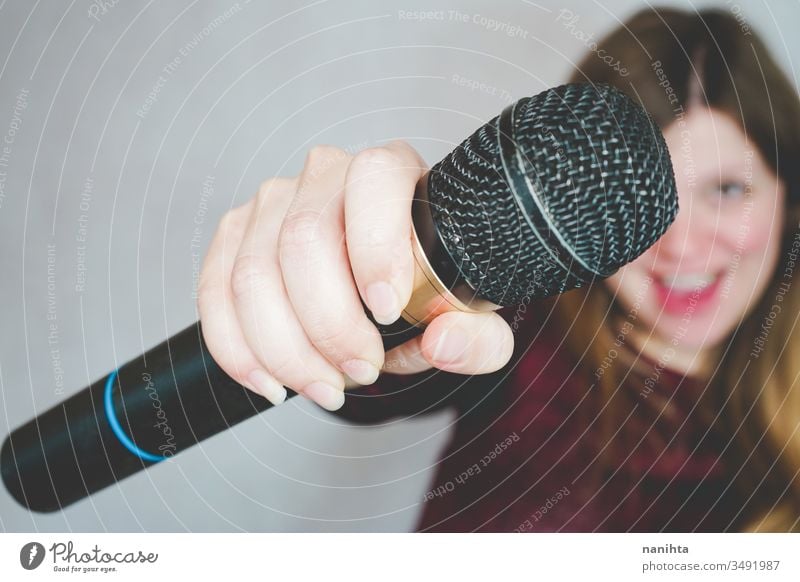 Young woman singing with a microphone loud techonology sound art artist concept leisure activity active blonde casual real people hobby trendy voice black