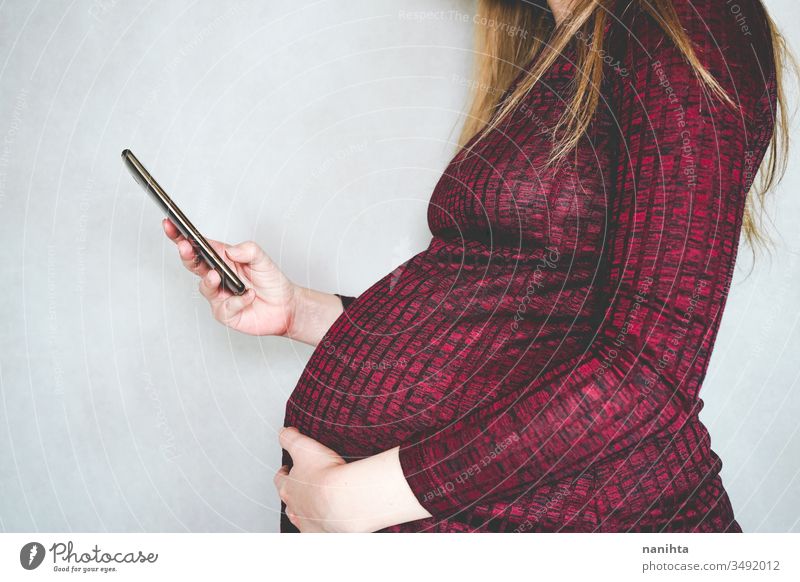 Young pregnant woman searching information with her smartphone pregnancy ask look for internet social media wifi technology mom mother motherhood belly tummy