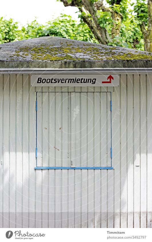 Reference to a boat rental boat hire Signage Arrow cot wood Roof Window Closed Signs and labeling Direction Deserted Exterior shot Lake Constance