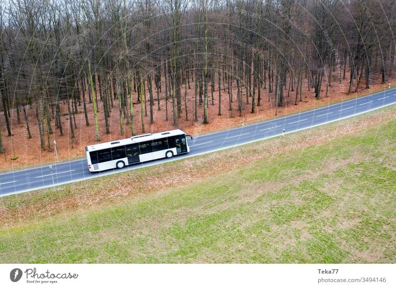 a white bus on a street from above drone public transportation winter forest
