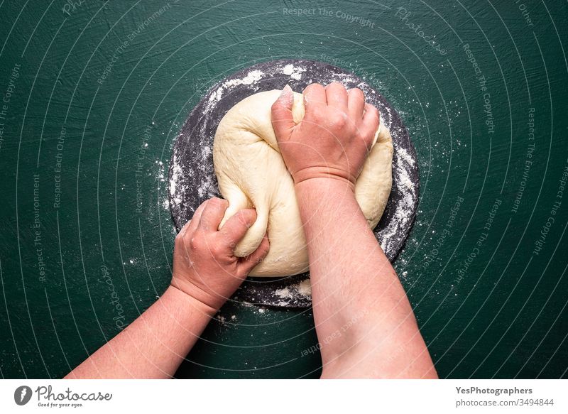 Kneading pizza dough on green table. Making dough at home above view bake bakery baking bread colorful cooking flat lay flour food healthy lifestyle home baking