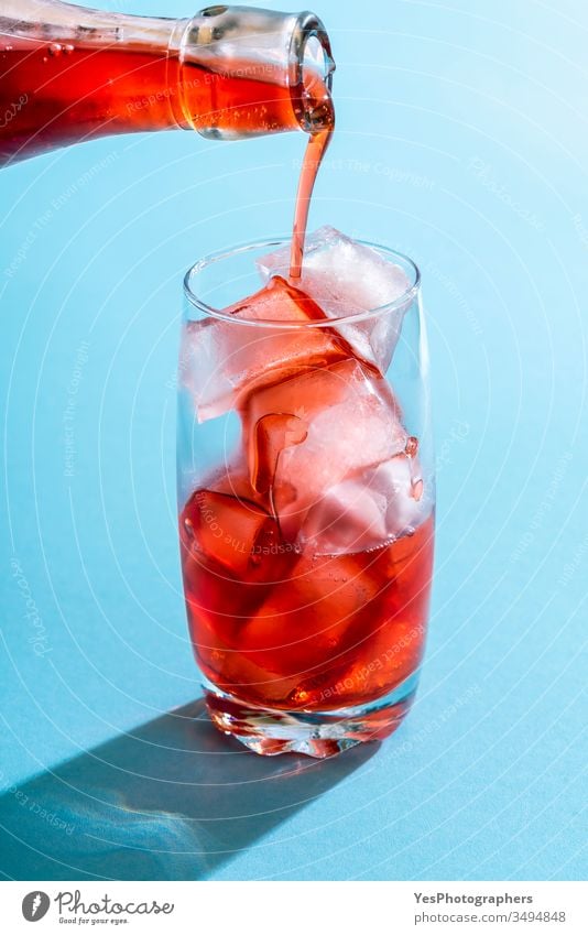 Pouring strawberry syrup over in a glass of water. beverage blue bright close-up cocktail cold drink colorful copy space crystal clear delicious detox