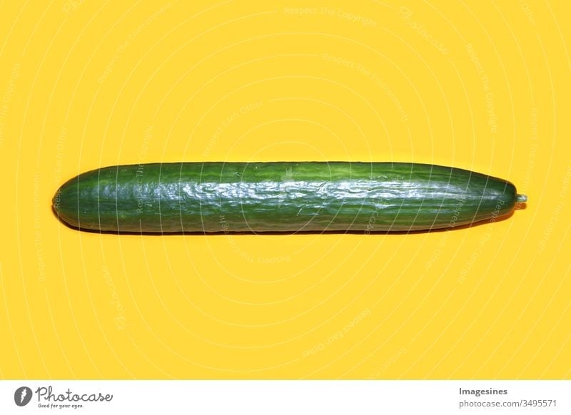 a whole long ripe green cucumber on yellow background. single cucumber Abstract backgrounds Close-up Cucumber cut detail Design Diet Eating food and drink