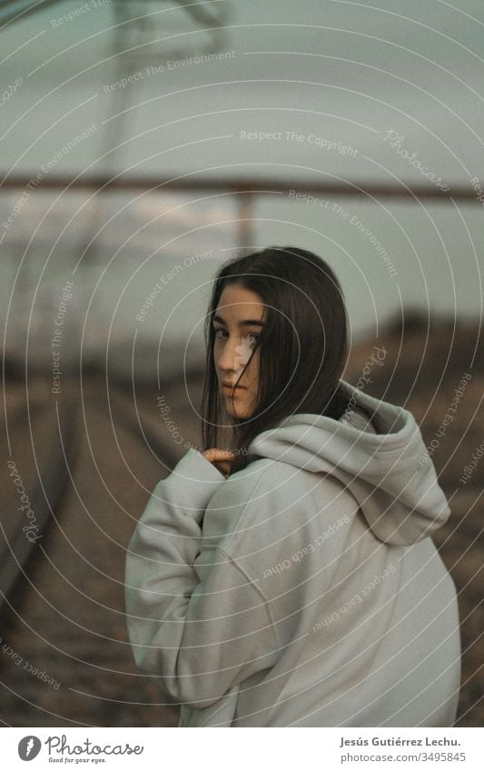 young hooded woman in a white sweatshirt with a serious look vintage background hair Face girl people Exterior shot Beauty Photography attractive Lifestyle