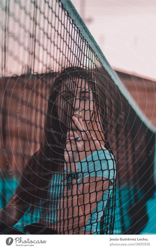 young woman leaning on a tennis net Style Woman Colour photo Beautiful Young woman Paint Human being Portrait photograph Fantasy Mystery light Conceptual design