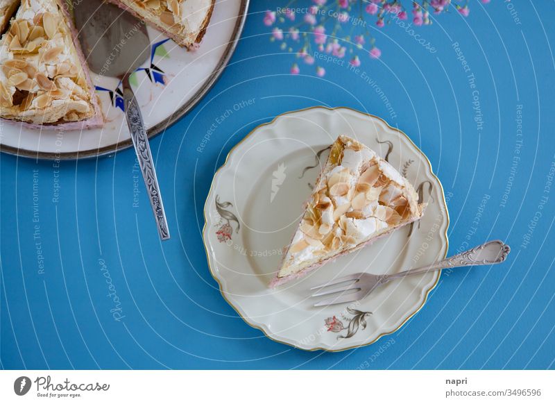 A piece of meringue cake on a vintage cake plate and a bright blue background. Piece of gateau Gateau Baiser homemade Dessert Sweet Delicious Retro tabletop