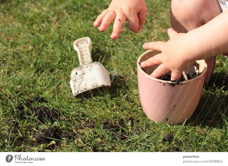 Small children as gardener's hands dig in soil. Pink flower pot and shovel Gardener Gardening Toddler grow Flowerpot Meadow Earth Sowing Pot hobby spring Nature