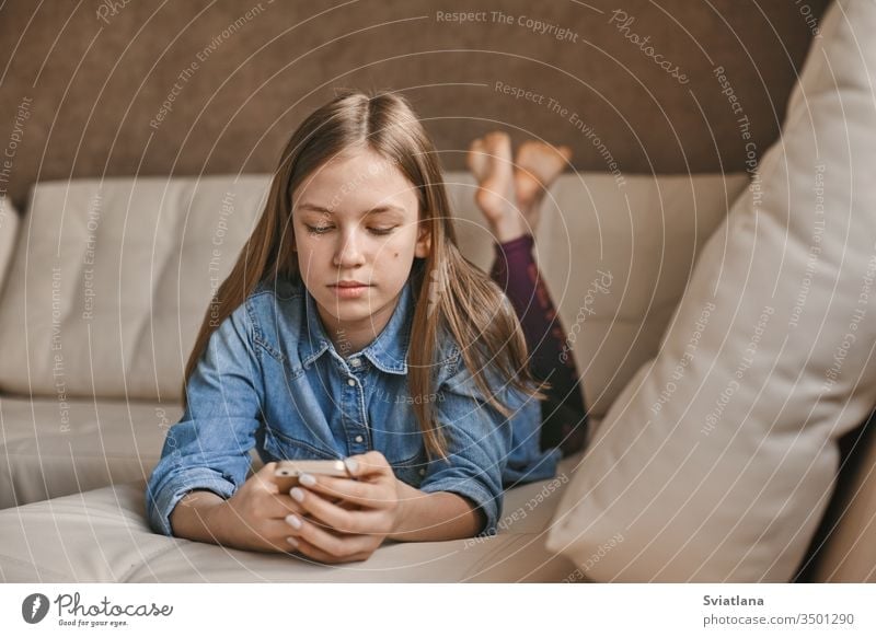 A beautiful teenage girl communicates with her friends via messenger during the quarantine. Self-isolation, communication, social distance during quarantine