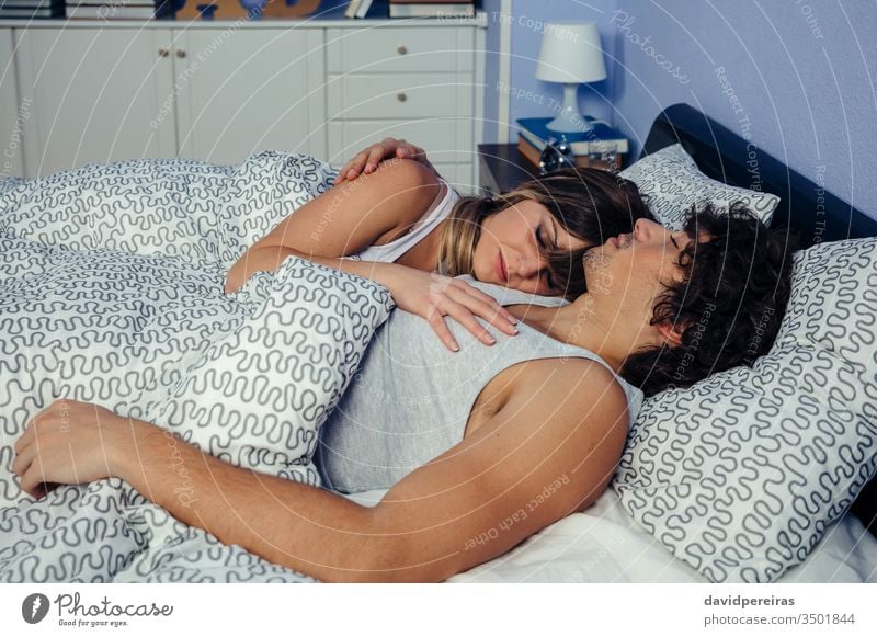 Couple sleeping embraced in bed couple romantic embracing love touching supported reclining peaceful together woman people beautiful caressing hugging home