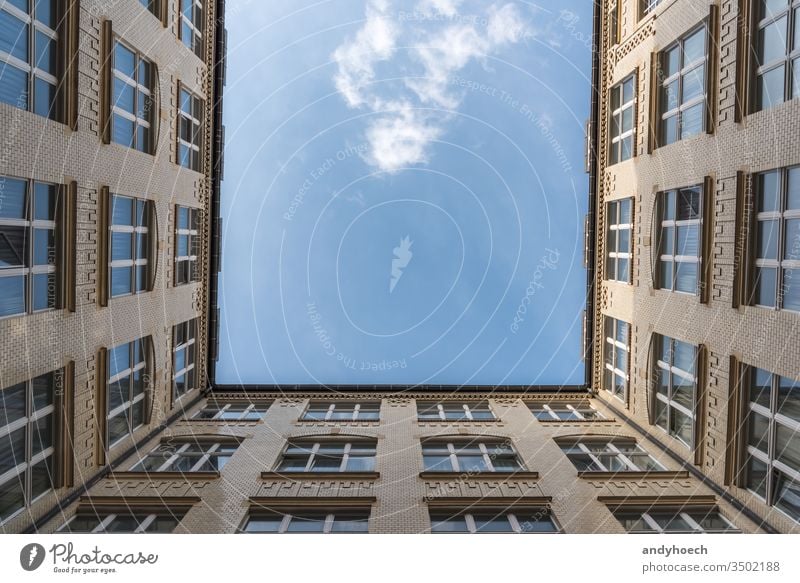 A look up at a white cloud from a courtyard apartment apartments architecture beautiful blue blue sky brick building buildings city clouds construction