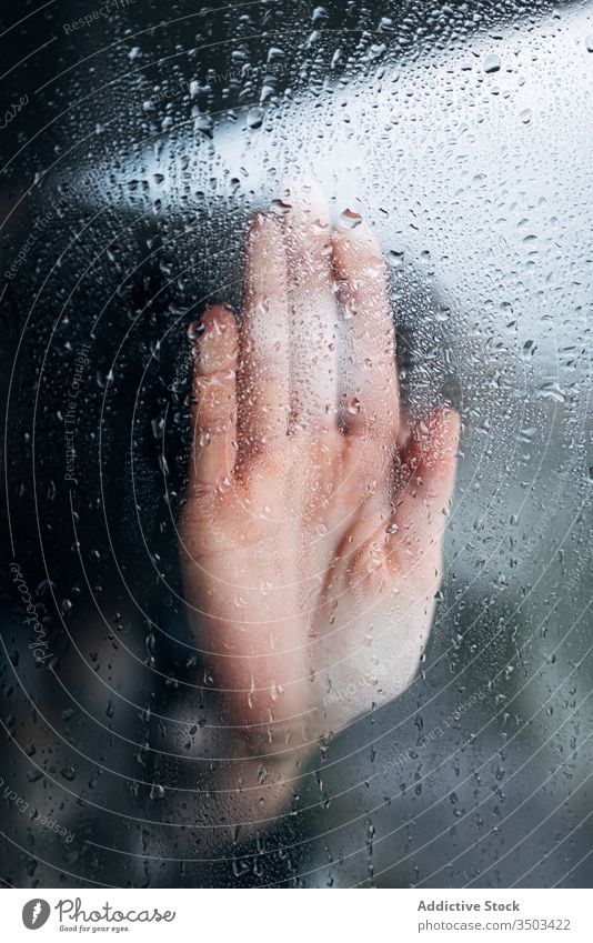Anonymous person touching glass of window hand home isolation desperate wet coronavirus lonely depression solitude rain problem concept unhappy stress