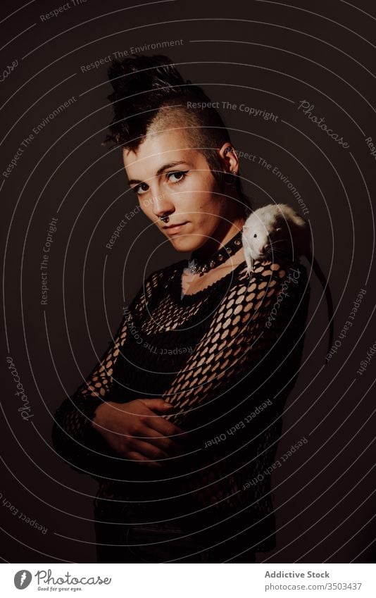 Female punk with rat on shoulder woman style confident pet subculture modern rebel mohawk appearance female dark model piercing individuality personality