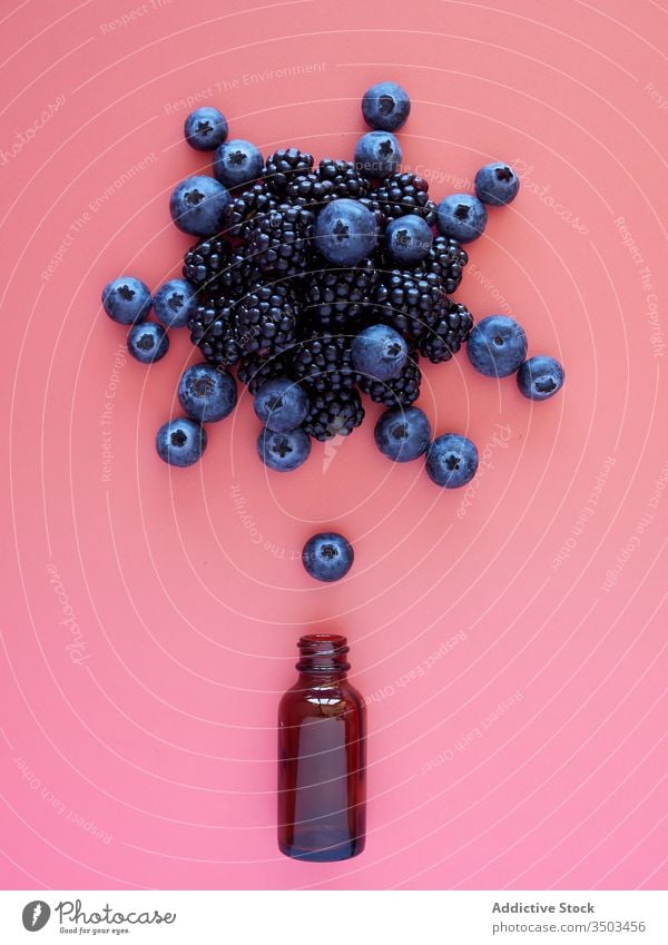 Fresh berries and glass jar on pink background berry bottle blueberry blackberry fresh ripe natural healthy food concept explosion drink dessert juice meal