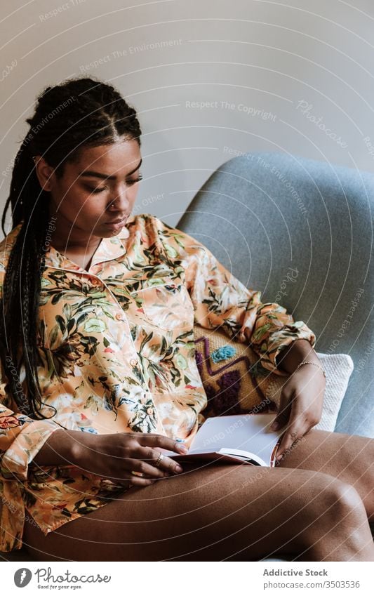 Ethnic woman with book resting at home read african american black casual chair brunette calm sitting young cozy ethnic female free time relax lifestyle
