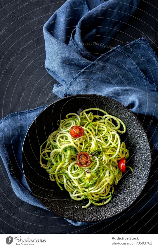 Homemade zucchini spaghetti with pesto sauce, broccoli and cherry tomatoes plate organic healthy green vegetarian raw spiral diet agriculture farming homemade