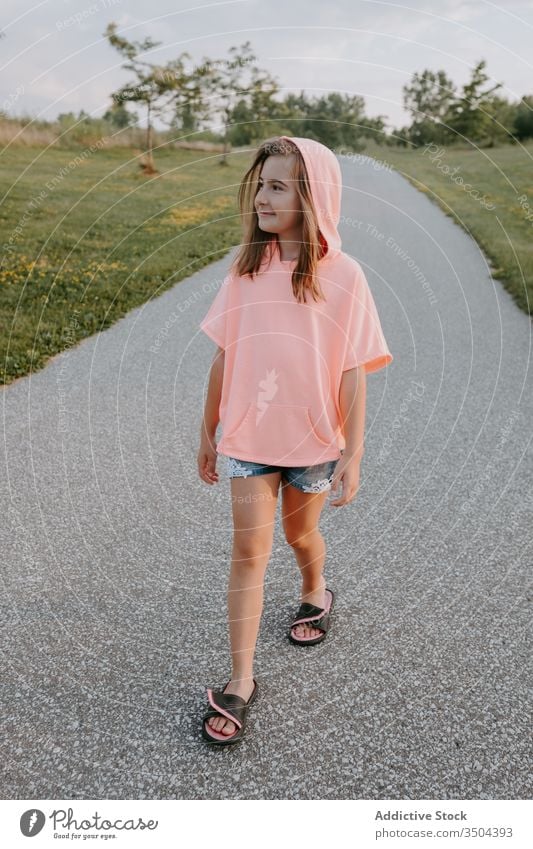 Happy girl walking on pathway in park summer countryside casual kid cheerful smile preteen happy female child enjoy activity green modern positive lifestyle