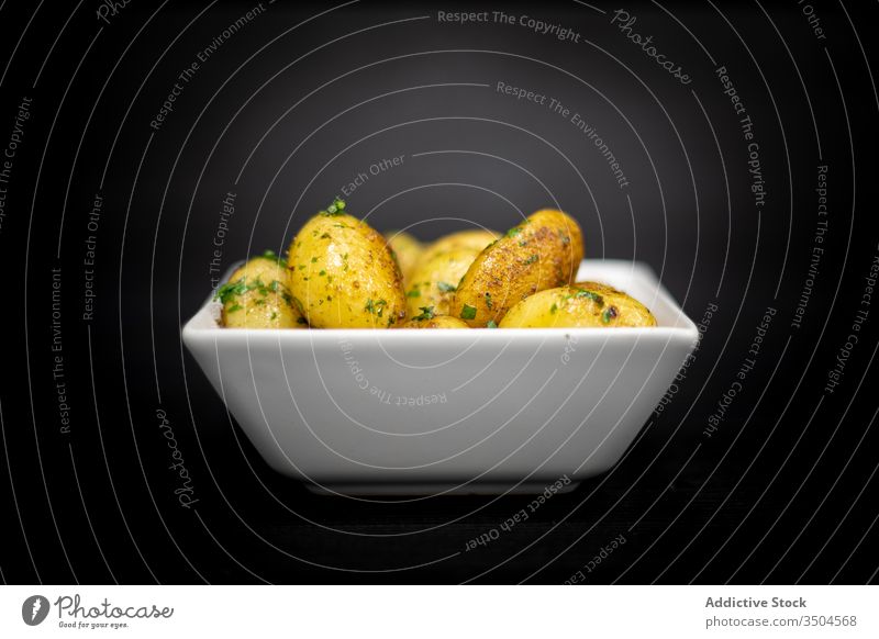 Bowl of baked potatoes with herbs roast bowl table cafe timber food meal dinner dish lunch fresh ingredient lumber black palatable gourmet cuisine delectable