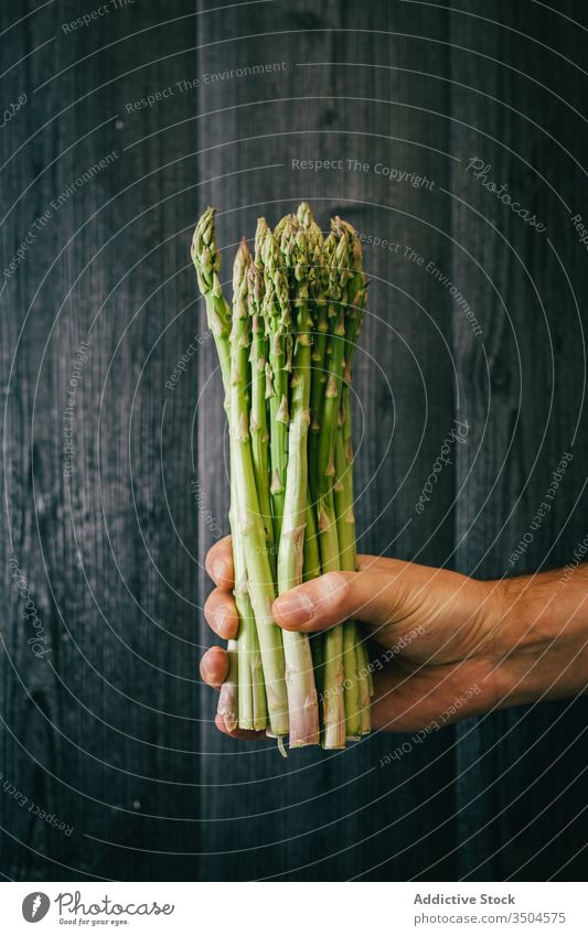 Crop person with a bunch of fresh asparagus healthy green diet show wall leaf wooden organic vegetarian vitamin timber black lumber food wellness meal
