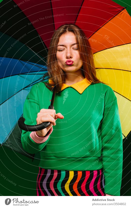 Young woman with colorful umbrella in studio style bright vivid young multicolored fashion female model urban confident accessory trendy individuality