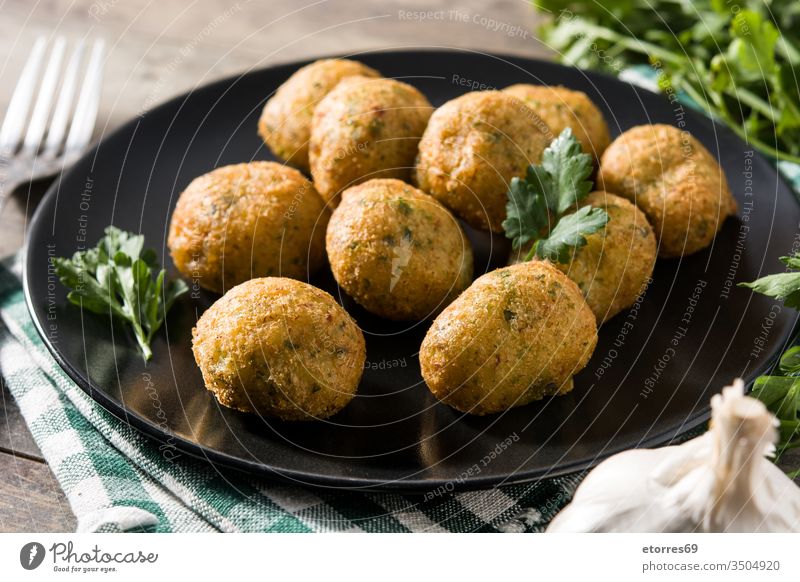 Traditional cod fritters decorated with garlic and parsley accras de morue bacalao balls buñuelos cod cake croquette cut out dish fish food fried holidays