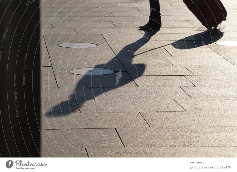 Shadow of a traveller with a wheeled suitcase - a Royalty Free Stock ...