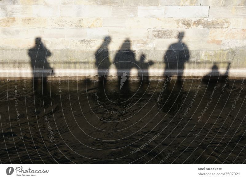 Shadows of a group of people sink into the water Group Water downfall Climate change River Wall (barrier) conceit Abstract differently Flood High tide Deluge