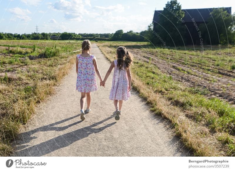 Two sisters play games off Field Village To go for a walk children gilrs Summer Sun nature