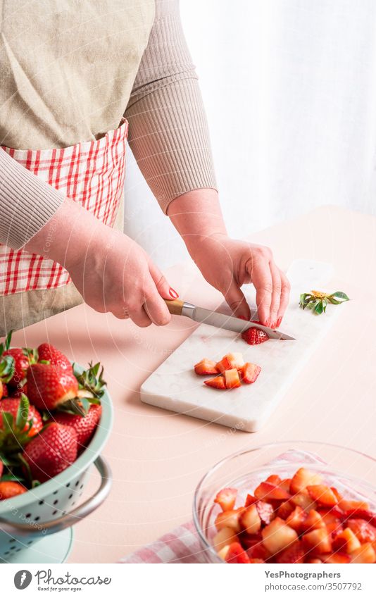 Housewife making strawberry jam. Woman cutting fruits berries classic cooking cut board cut pieces dessert domestic kitchen food food preparation fresh