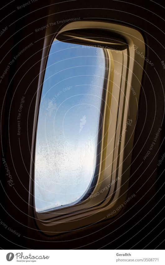 airplane window with frost on the glass isolated background black blue closeup flight hoarfrost ice pattern pattern on glass porthole sky technique travel