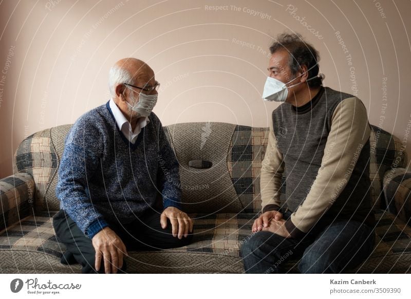 An elderly and a senior man wearing masks chatting about covid19 turkey turkish corona virus quarantine curfew infection europe street home indoor stayhome