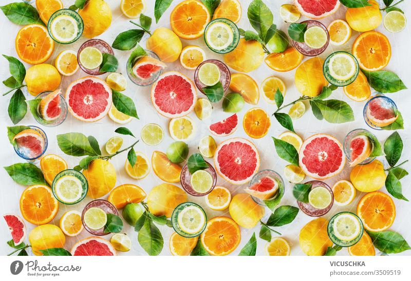 Citrus fruits background made with whole, halves and slices of various citrus with green leaves. Top view. Flat lay. Healthy eating. Vitamin. Drink ingredients.