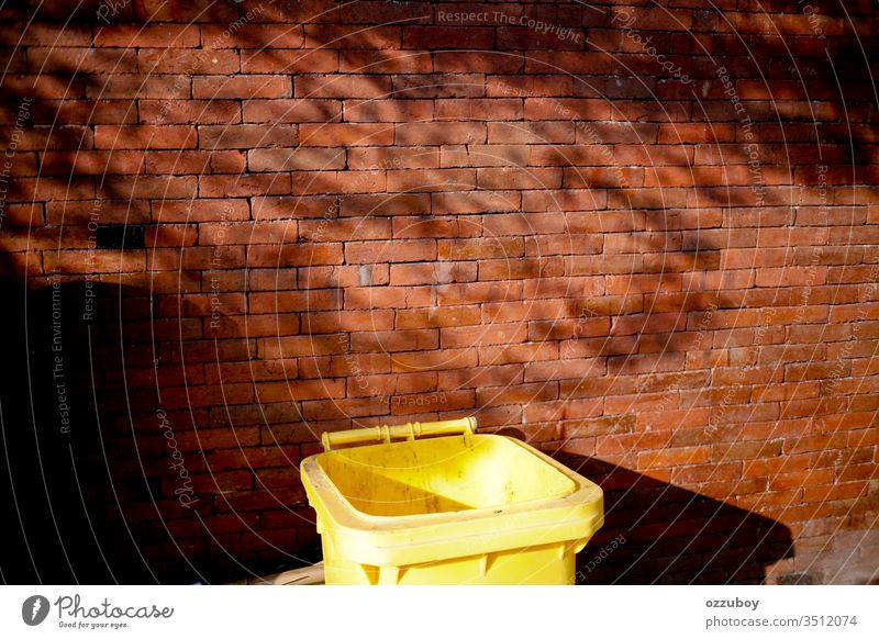 close up garbage bin Wall (building) Brick Brick wall Copy Space Yellow Red Garbage dump garbage can Trash container Shadow simplicity Shadow play Plant