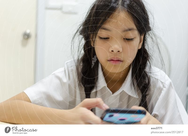 children addicted to smart phone games addiction asia asian beautiful cell cellphone childhood communication concept cute digital education enjoy face female