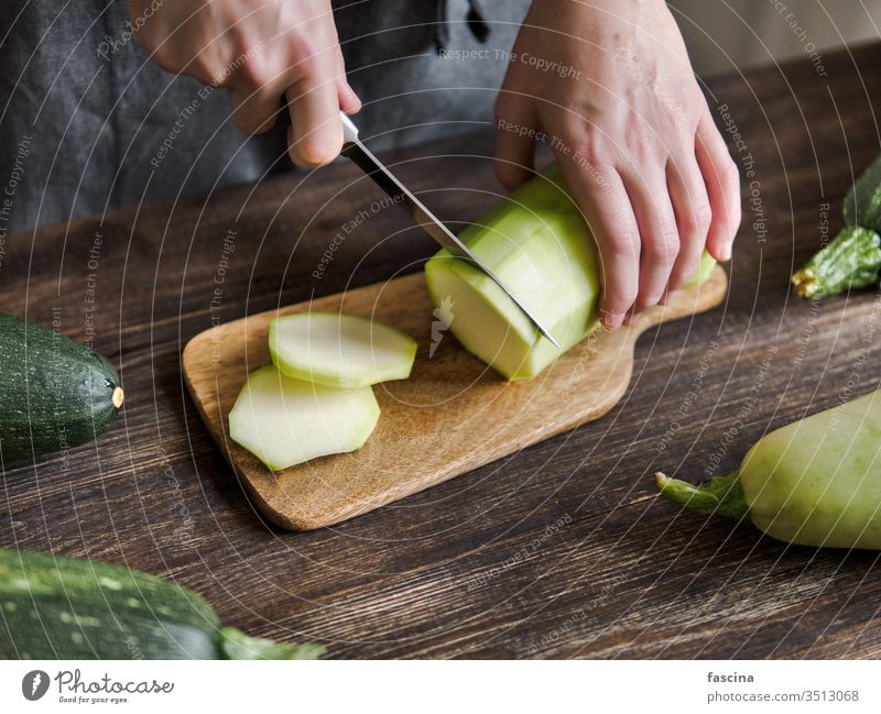 Zucchini harvesting concept. zucchini sliced woman female hand knife cut fresh organic vegetable green ingredient courgette food plant raw summer vegetarian