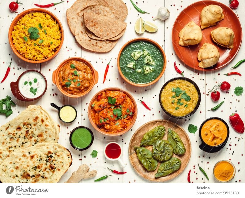 Indian food and indian cuisine dishes, top view meal overhead curry spicy chili lamb meat hot white samosa bread chicken tikka rice naan dal banquet frame asian