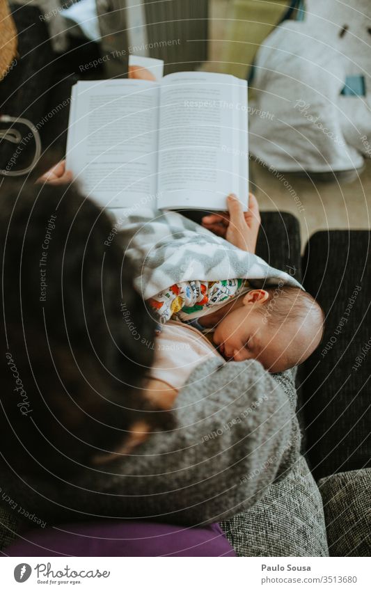 Baby sleeping on mother's lap while she is reading Newborn Sleep Small Child Caucasian White Life Delightful Portrait photograph Beautiful Innocent Infancy