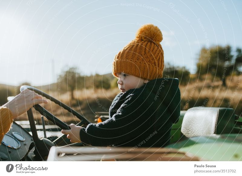 Child on the steering wheel childhood Steering wheel Driving Transport Colour photo Human being outdoors Exterior shot 1 - 3 years Childhood memory Infancy