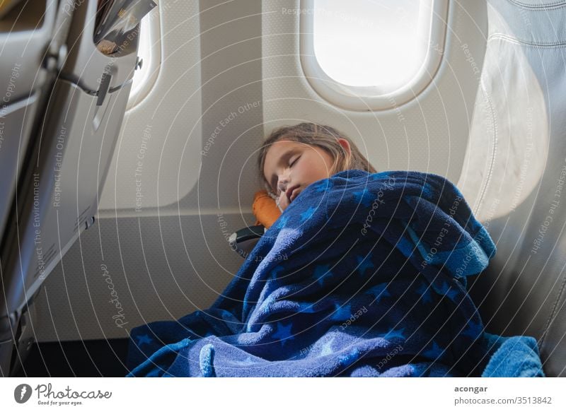 Girl sleeping inside the airplane during the flight Child aeroplane aircraft airline bedtime blanket boring caucasian chair childhood comfortable cover cute